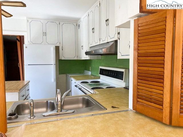 453 Smith Acres Road Ennice, NC 28623 - Photo 10 of 30 a kitchen with stainless steel appliances granite countertop a sink and a refrigerator