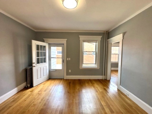 13 Spruce Street, Unit A Waltham, MA 02453 - Photo 5 of 13 an empty room with wooden floor and windows