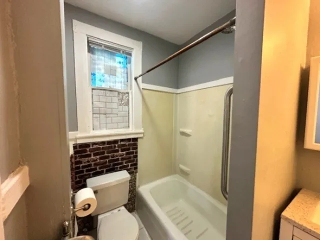 a bathroom with a toilet and shower