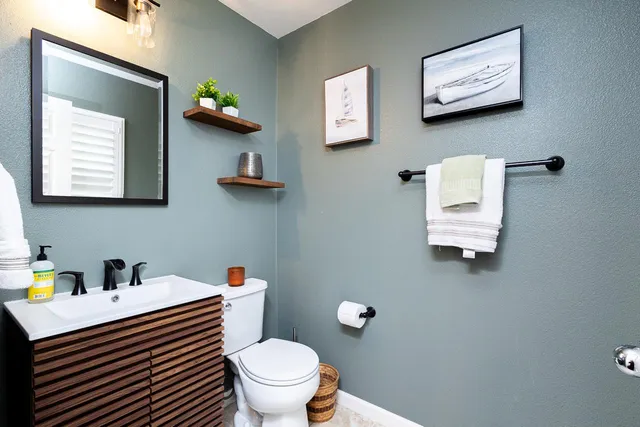a bathroom with a sink a toilet and mirror