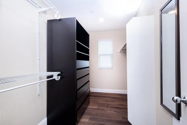 a view of walk in closet with wooden floor