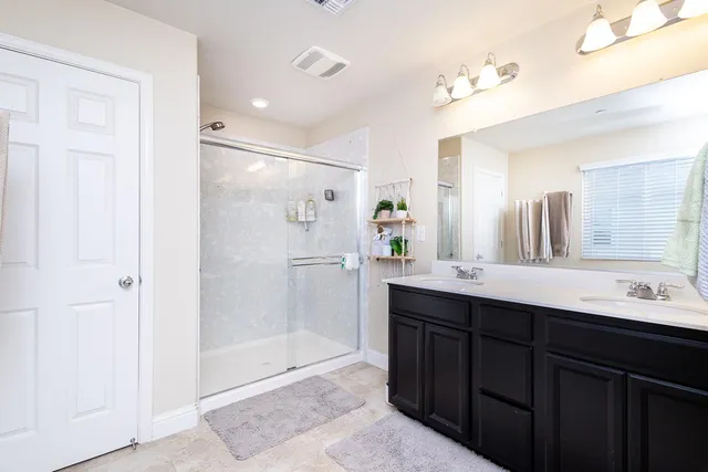 a bathroom with a shower sink and mirror