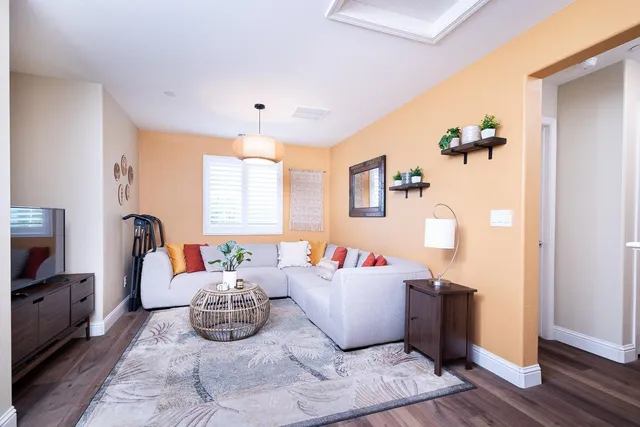 a living room with furniture a window and wooden floor