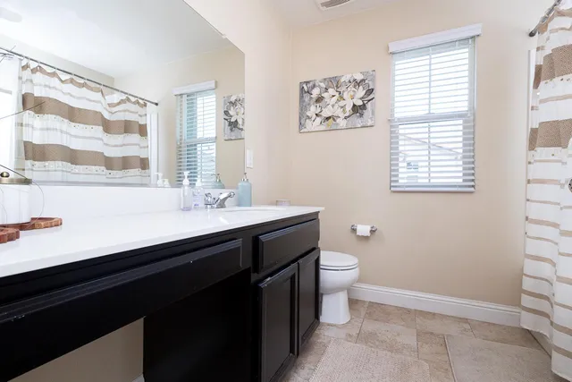 a bathroom with a double vanity sink toilet and a mirror