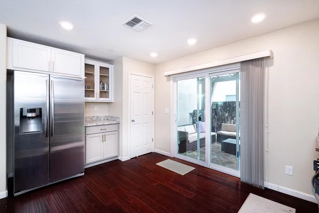 a kitchen with stainless steel appliances wooden floor and large window