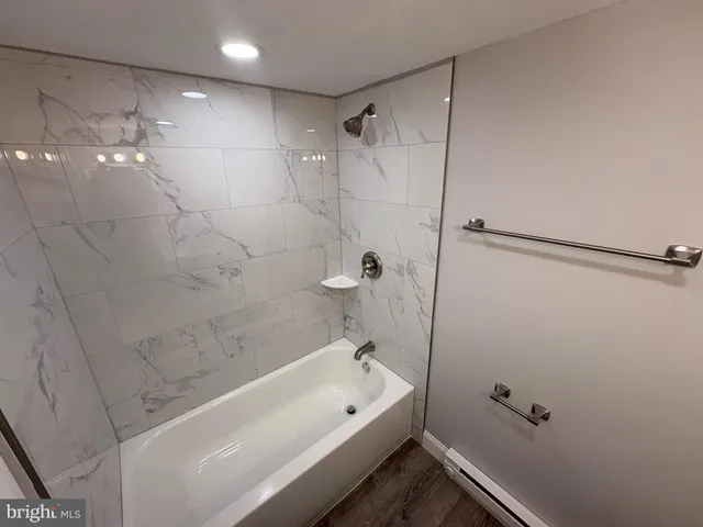 a bathroom with a white bath tub and a shower