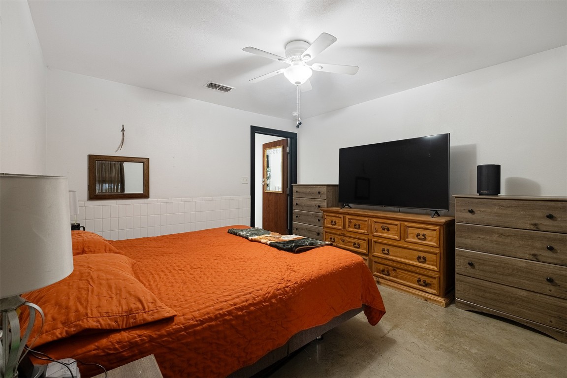 142 Zimmerhanzel Road Flatonia, TX 78941 - Photo 16 of 40 a bedroom with a bed and a flat screen tv