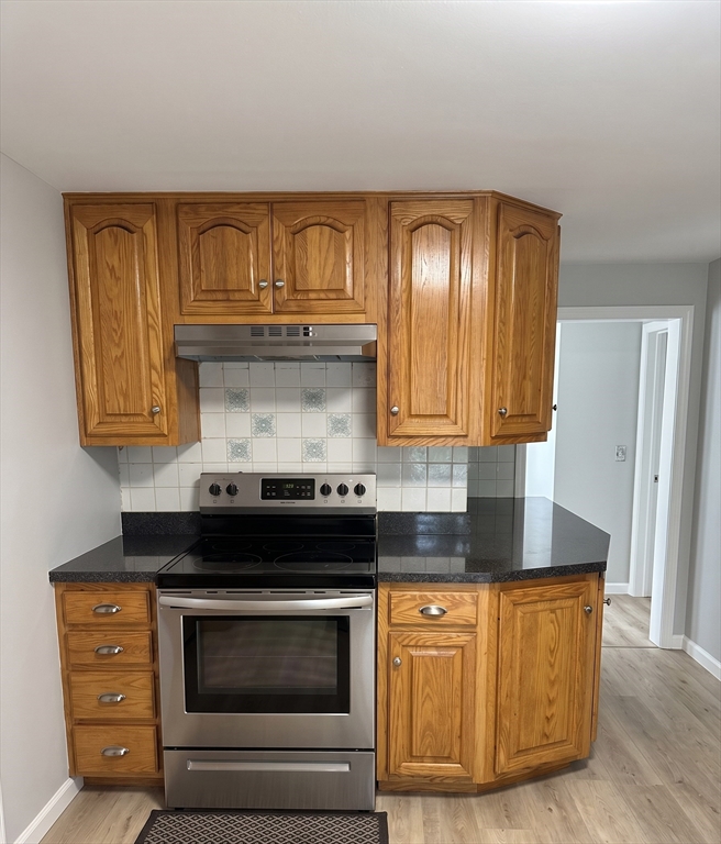 27 High Street Sturbridge, MA 01518 - Photo 9 of 17 a kitchen with granite countertop wood cabinets and stainless steel appliances
