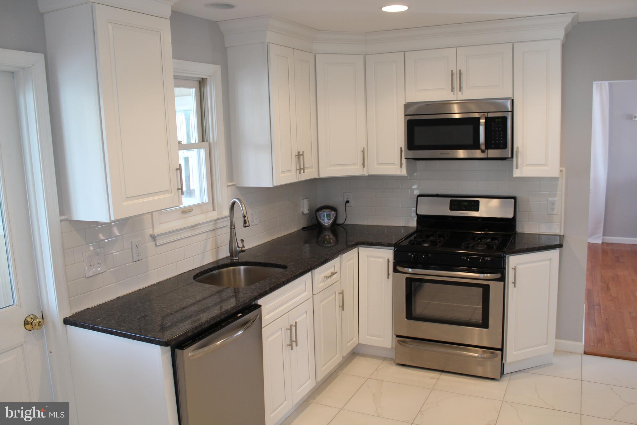 82 Baylor Road Hamilton, NJ 08610 - Photo 7 of 17 a kitchen with granite countertop white cabinets and stainless steel appliances