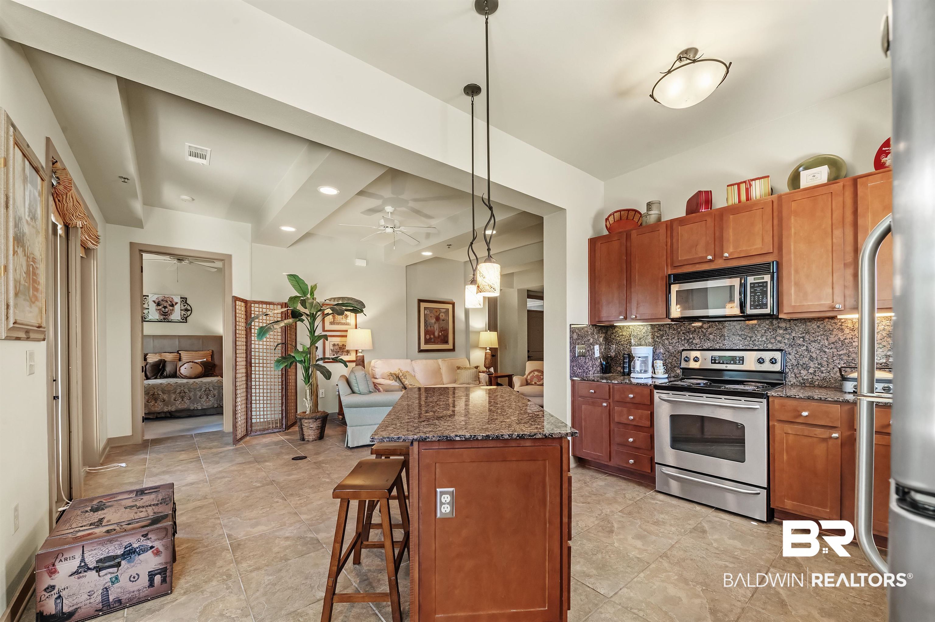 1430 Regency Road, Unit A301 Gulf Shores, AL 36542 - Photo 16 of 47 Kitchen featuring stainless steel appliances, backsplash, a center island, a kitchen bar, and decorative light fixtures