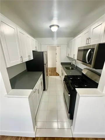 a kitchen with stainless steel appliances a stove a microwave a sink and cabinets