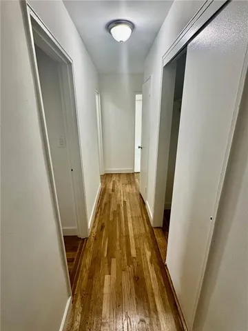 a view of a hallway with wooden floor and staircase