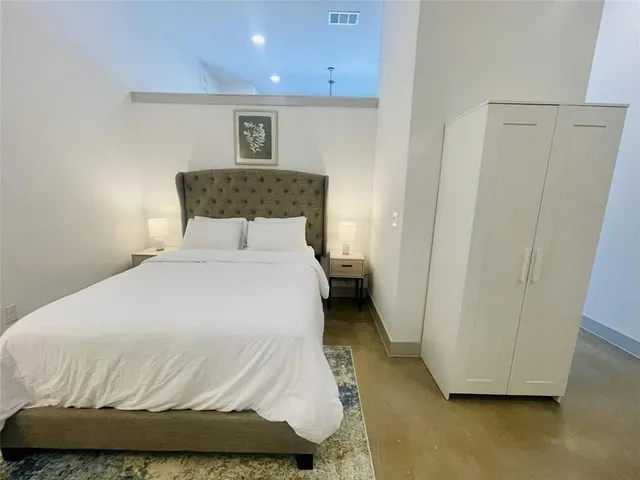 a bedroom with a bed and a night stand