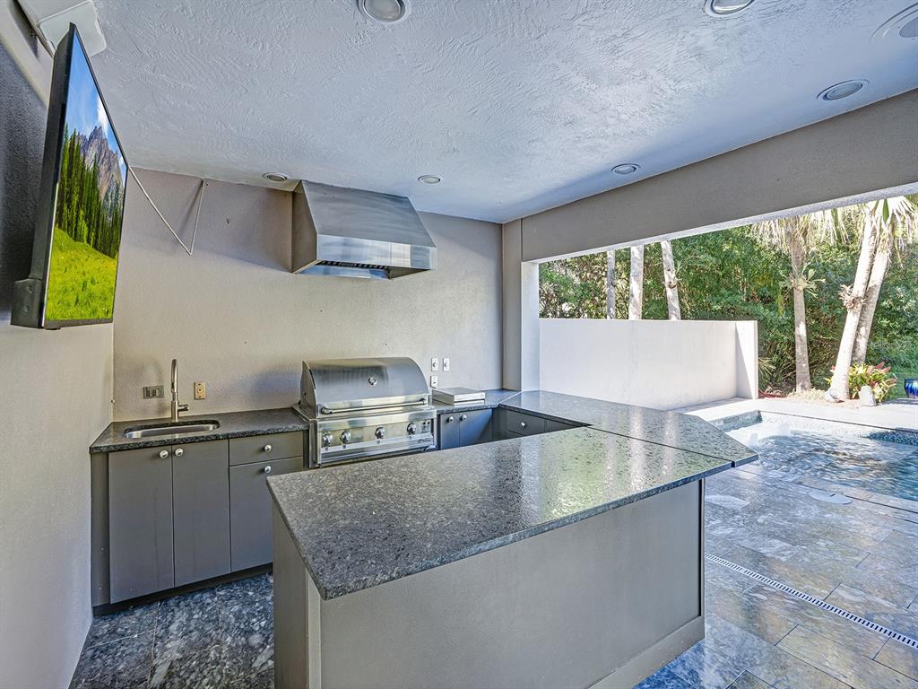 1609 Hampton Court Safety Harbor, FL 34695 - Photo 43 of 78 a kitchen with stainless steel appliances granite countertop a sink a stove and a wooden floors