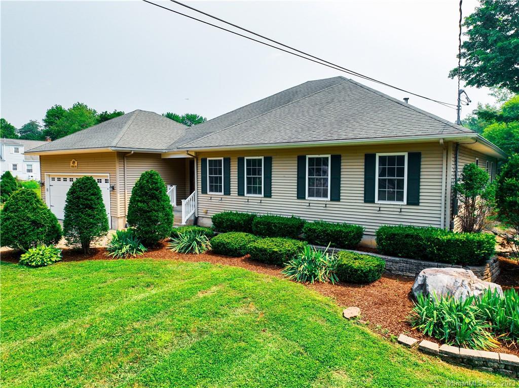 a front view of a house with a yard and potted plants