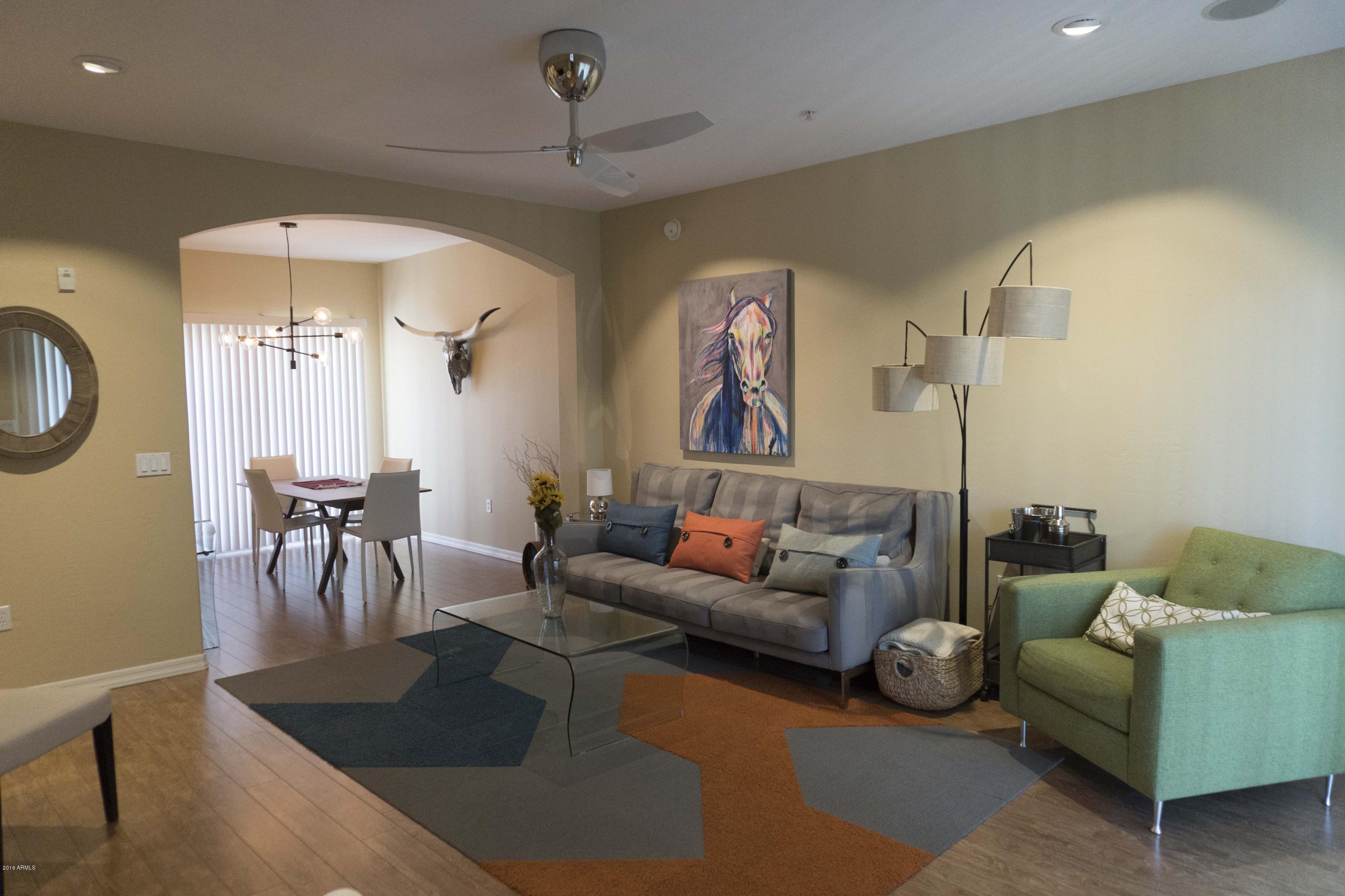 3935 East Rough Rider Road, Unit 1027 Phoenix, AZ 85050 - Photo 2 of 42 a living room with furniture and a chandelier