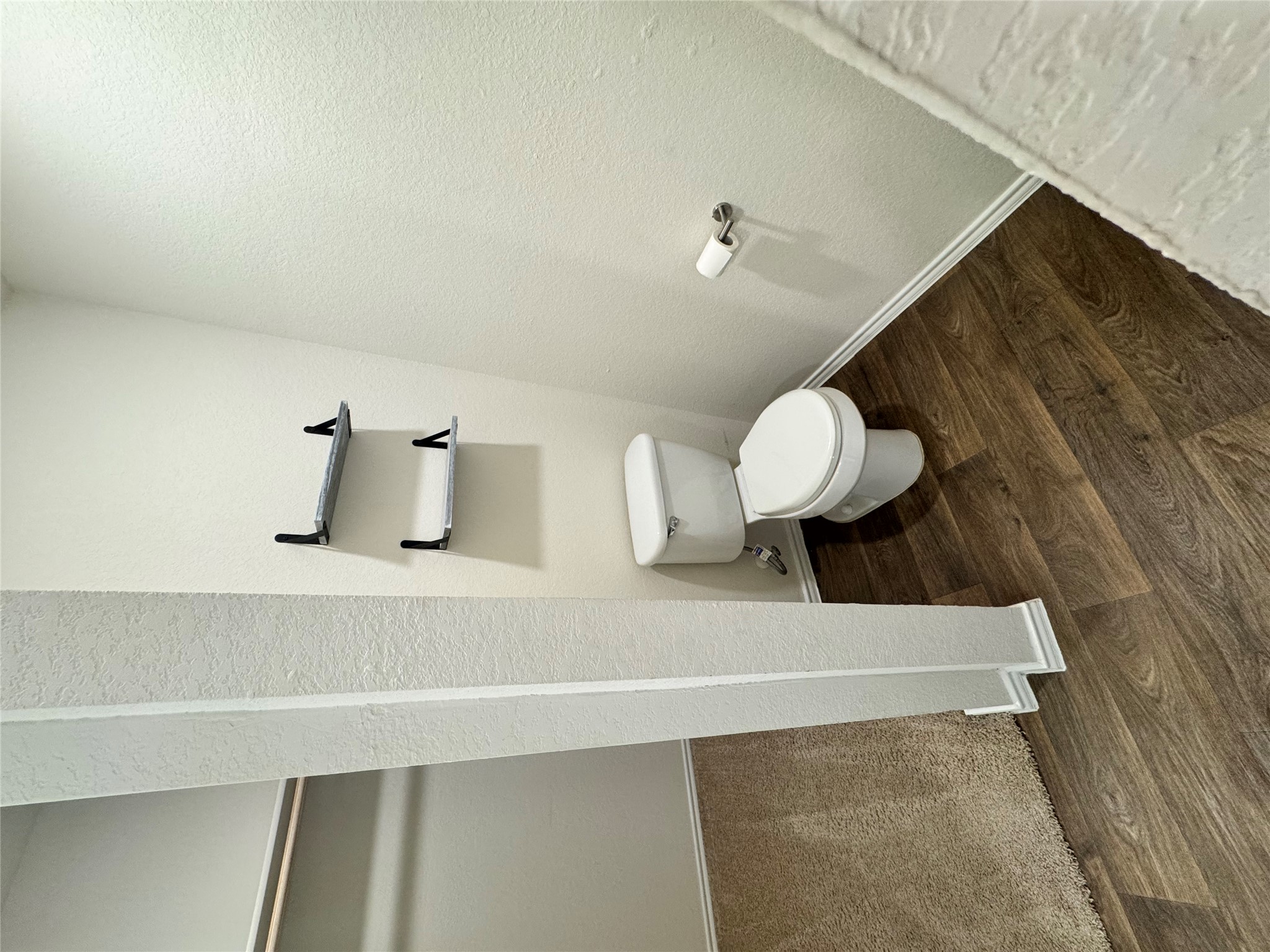 11820 Rush Lane Elgin, TX 78621 - Photo 23 of 31 Functional half-bath featuring stylish wood-look flooring and convenient wall-mounted shelving.