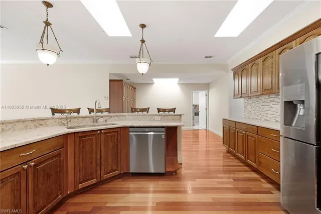 a large kitchen with stainless steel appliances granite countertop a sink and wooden floor