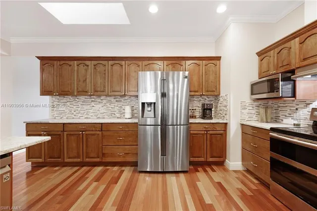 a kitchen with stainless steel appliances granite countertop a refrigerator stove top oven and sink