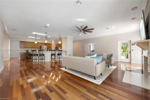 a living room with furniture and a dining table with wooden floor