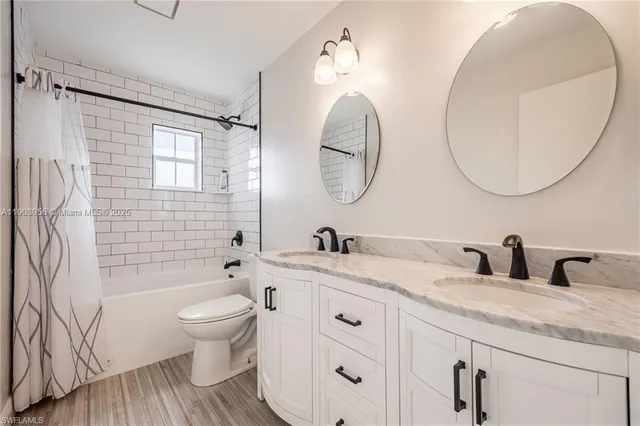 a bathroom with a granite countertop toilet sink and mirror