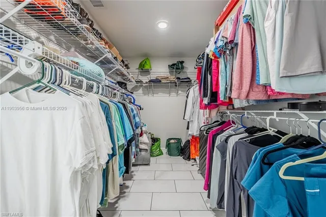 a view of walk in closet with clothes and shoes