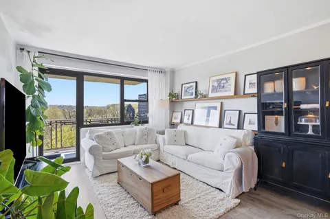 a living room with furniture and a view of kitchen