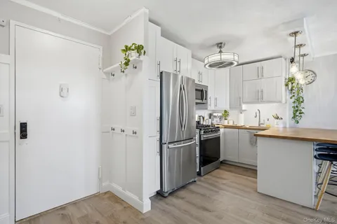 a open kitchen with stainless steel appliances kitchen island granite countertop a sink and a refrigerator