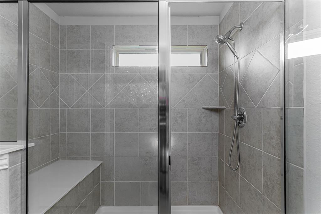 129 Springwood Ranch Loop Springtown, TX 76082 - Photo 17 of 29 Tiled shower enclosure featuring a fixed window, built-in bench, and a handheld shower fixture