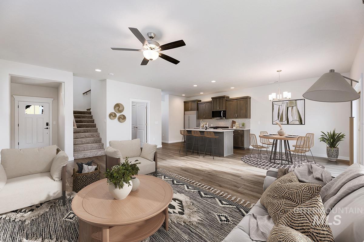 219 West Broyhill Street Meridian, ID 83642 - Photo 3 of 25 Living room with stairway, a chandelier, ceiling fan, light wood finished floors, and recessed lighting