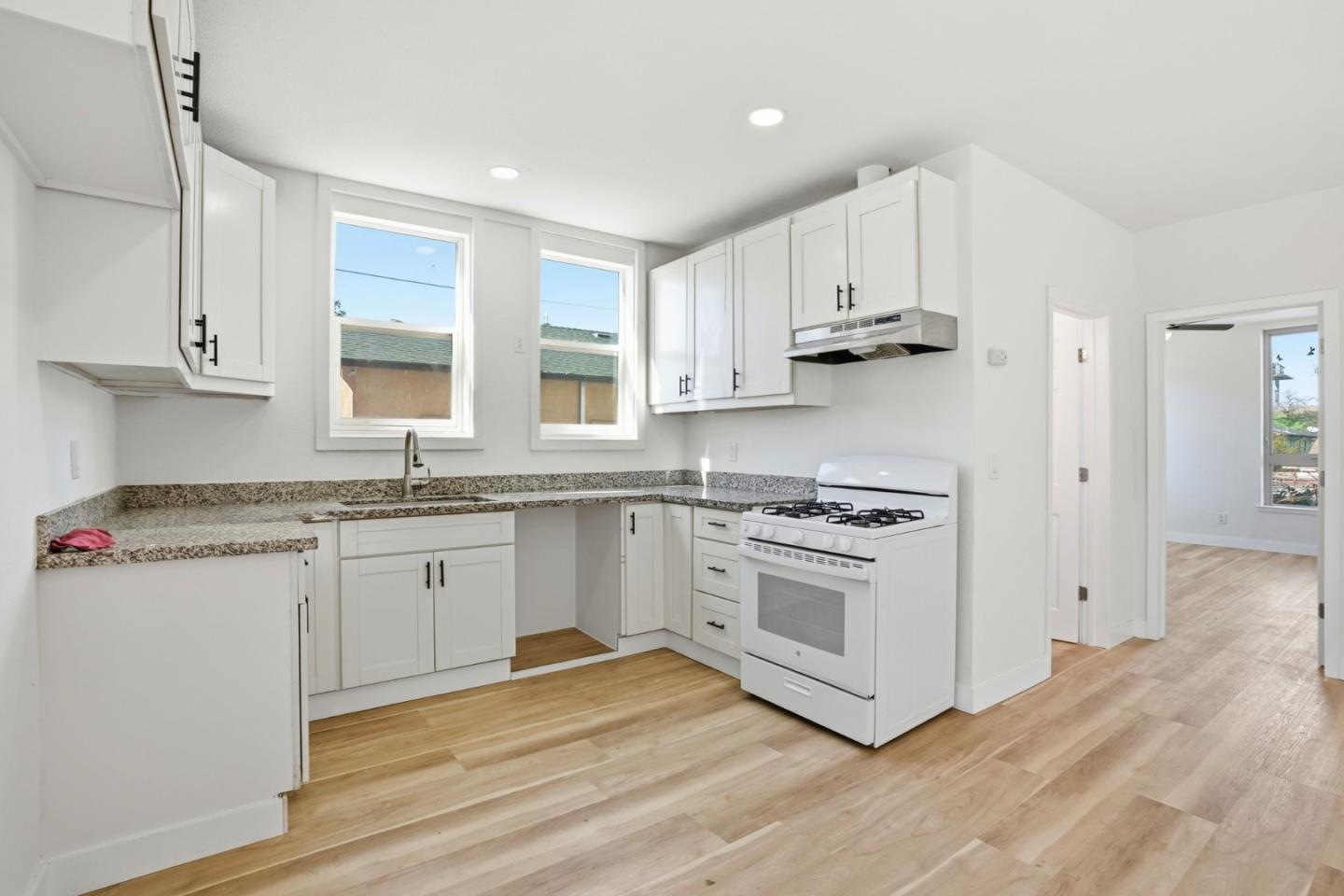 a kitchen with stainless steel appliances granite countertop a sink a stove and a refrigerator