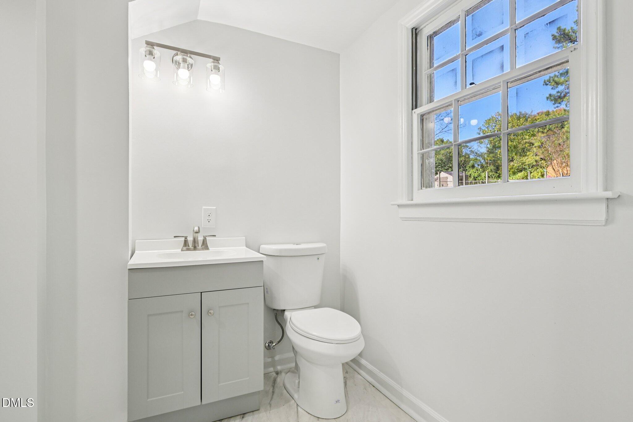 515 Uzzle Street Durham, NC 27713 - Photo 24 of 26 a bathroom with a toilet a sink and a window