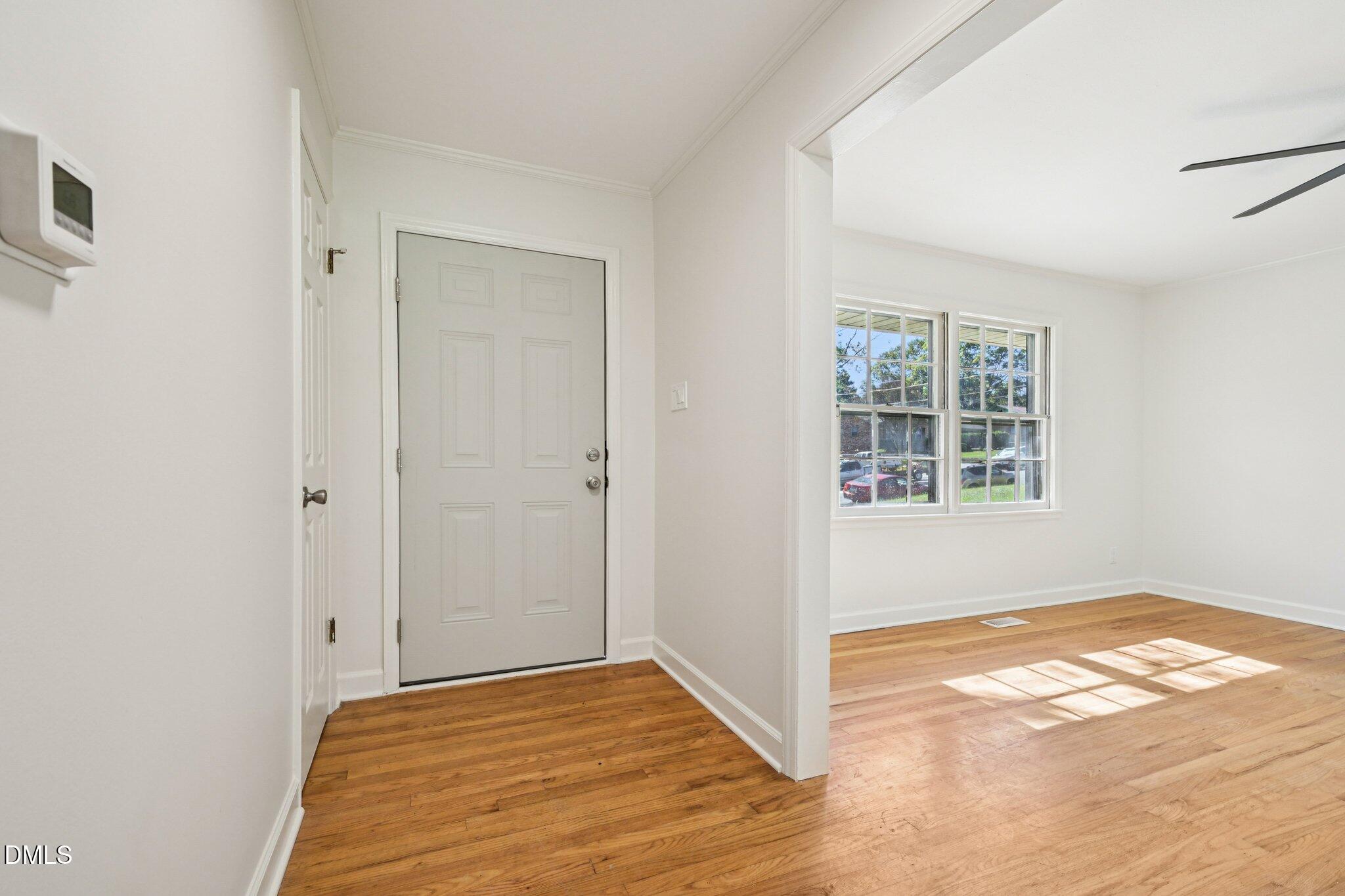 515 Uzzle Street Durham, NC 27713 - Photo 4 of 26 a view of an empty room with window and wooden floor