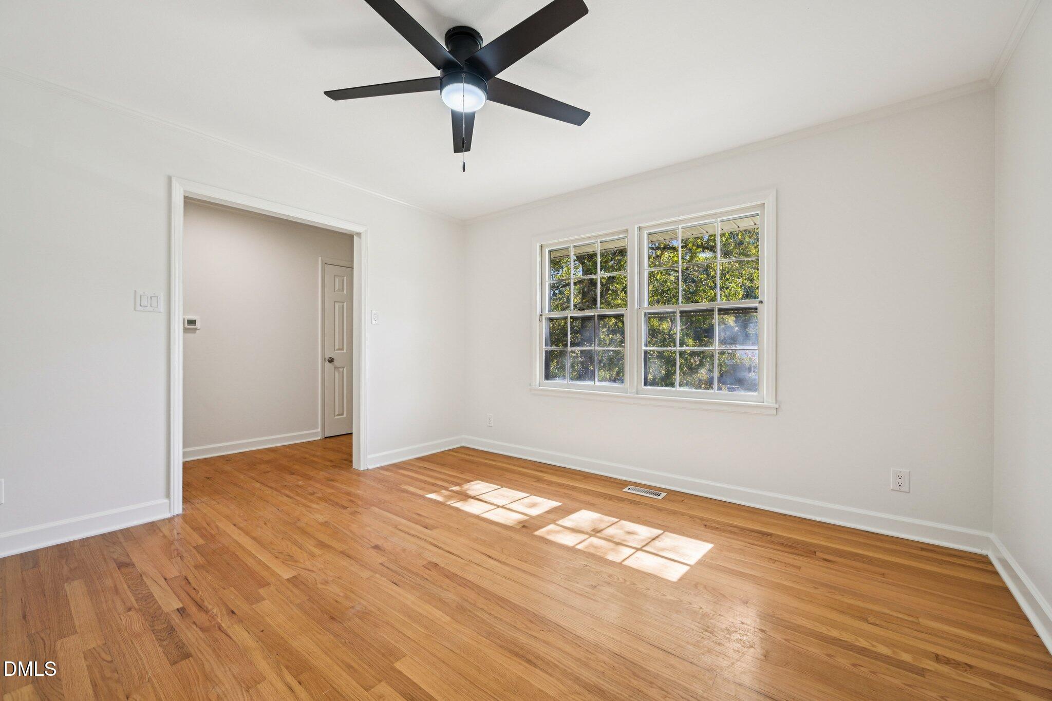 515 Uzzle Street Durham, NC 27713 - Photo 5 of 26 an empty room with wooden floor and windows