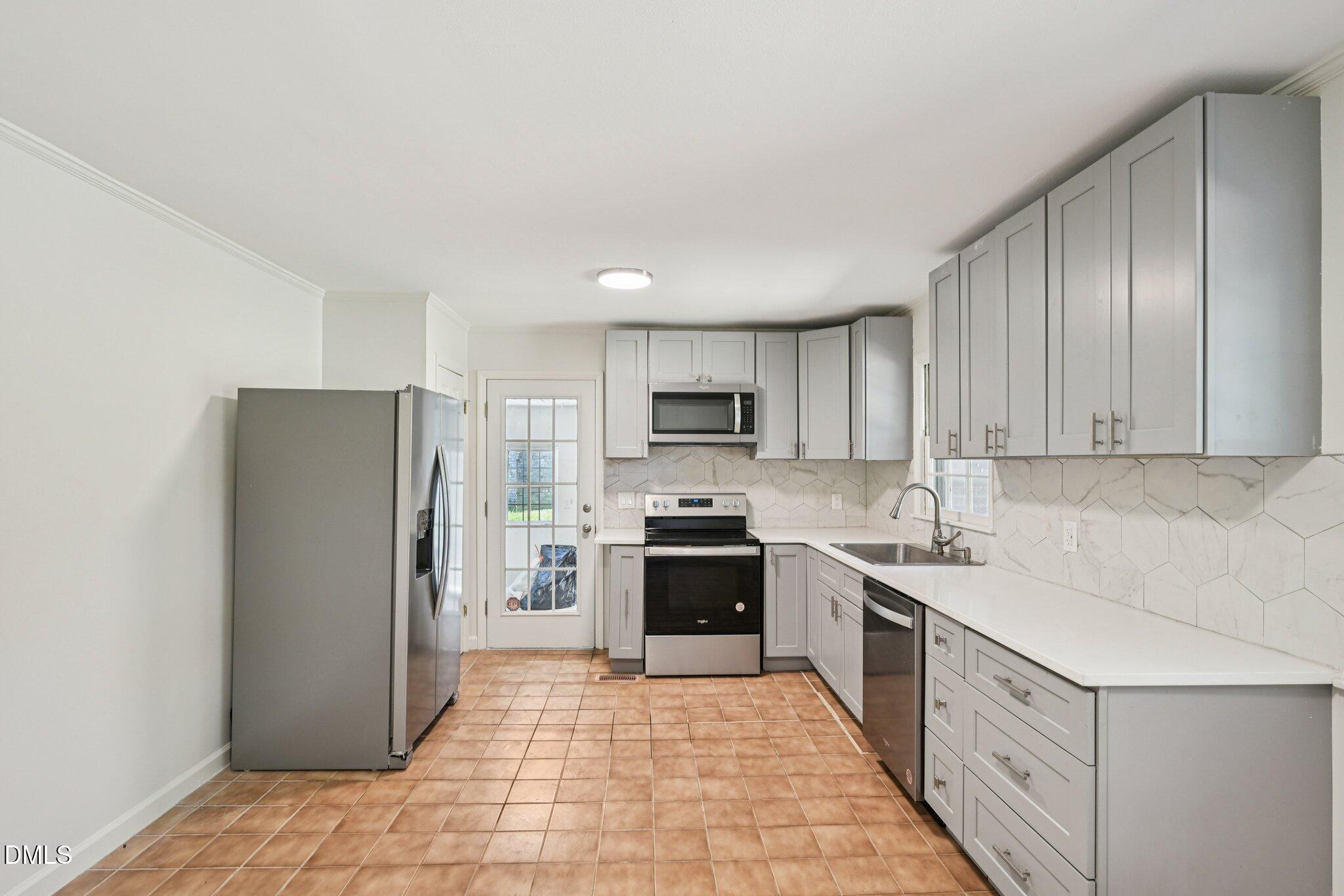 515 Uzzle Street Durham, NC 27713 - Photo 6 of 26 a kitchen with stainless steel appliances granite countertop a refrigerator stove and sink