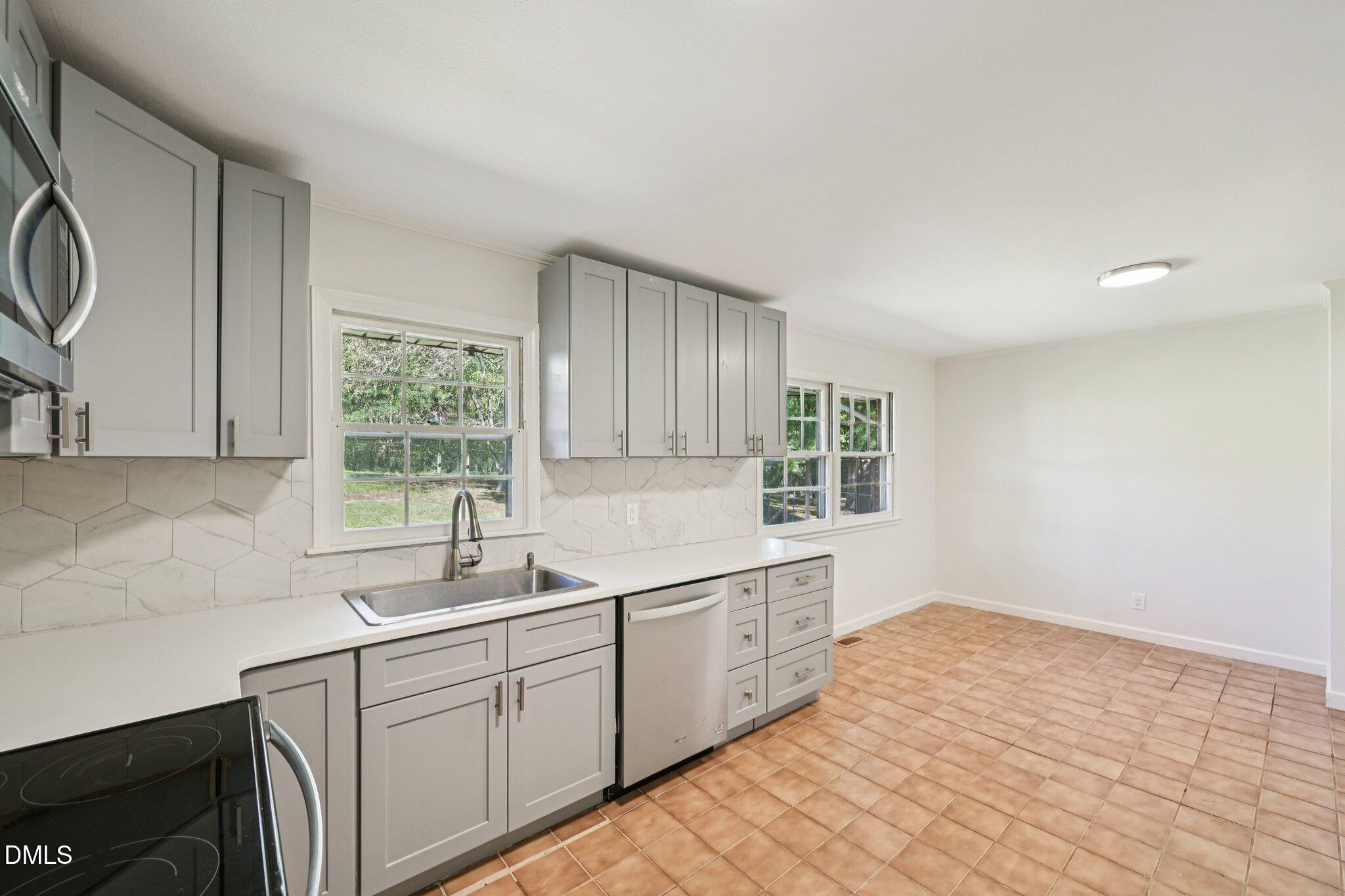 515 Uzzle Street Durham, NC 27713 - Photo 8 of 26 a kitchen with a sink cabinets and window