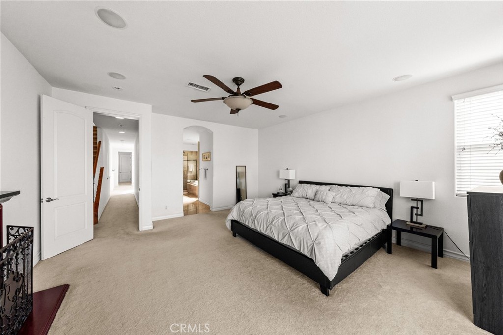 116 11th Street Huntington Beach, CA 92648 - Photo 21 of 28 a spacious bedroom with a bed and a ceiling fan