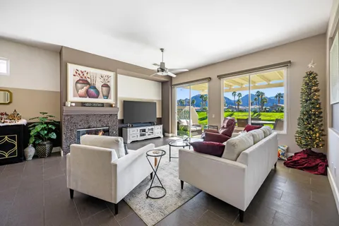 a living room with furniture a flat screen tv and a large window