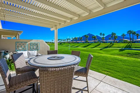 a view of a wooden chairs and table in the back yard