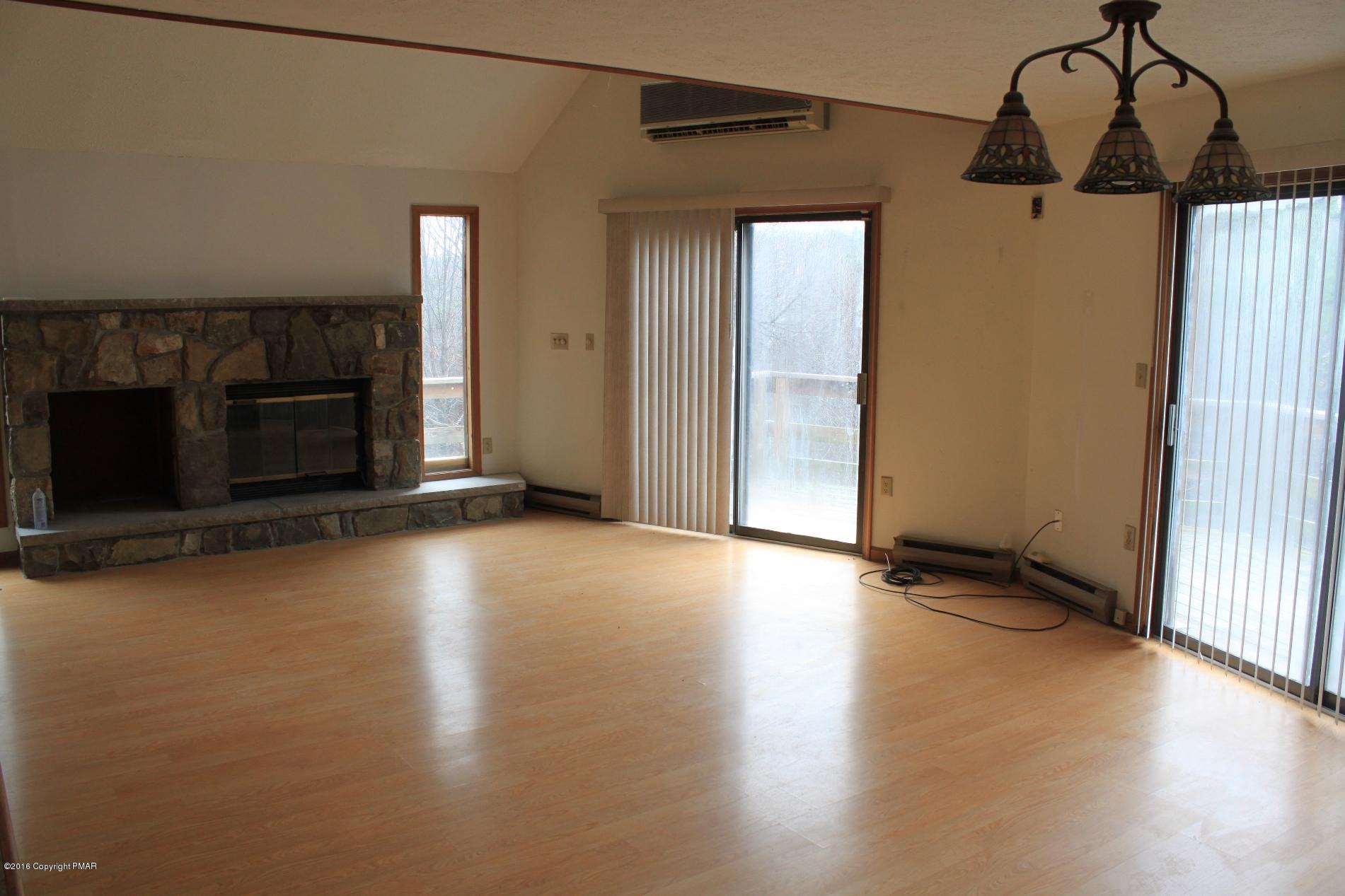 1421 Clover Road Long Pond, PA 18334 - Photo 4 of 26 a view of a livingroom with wooden floor and a fireplace