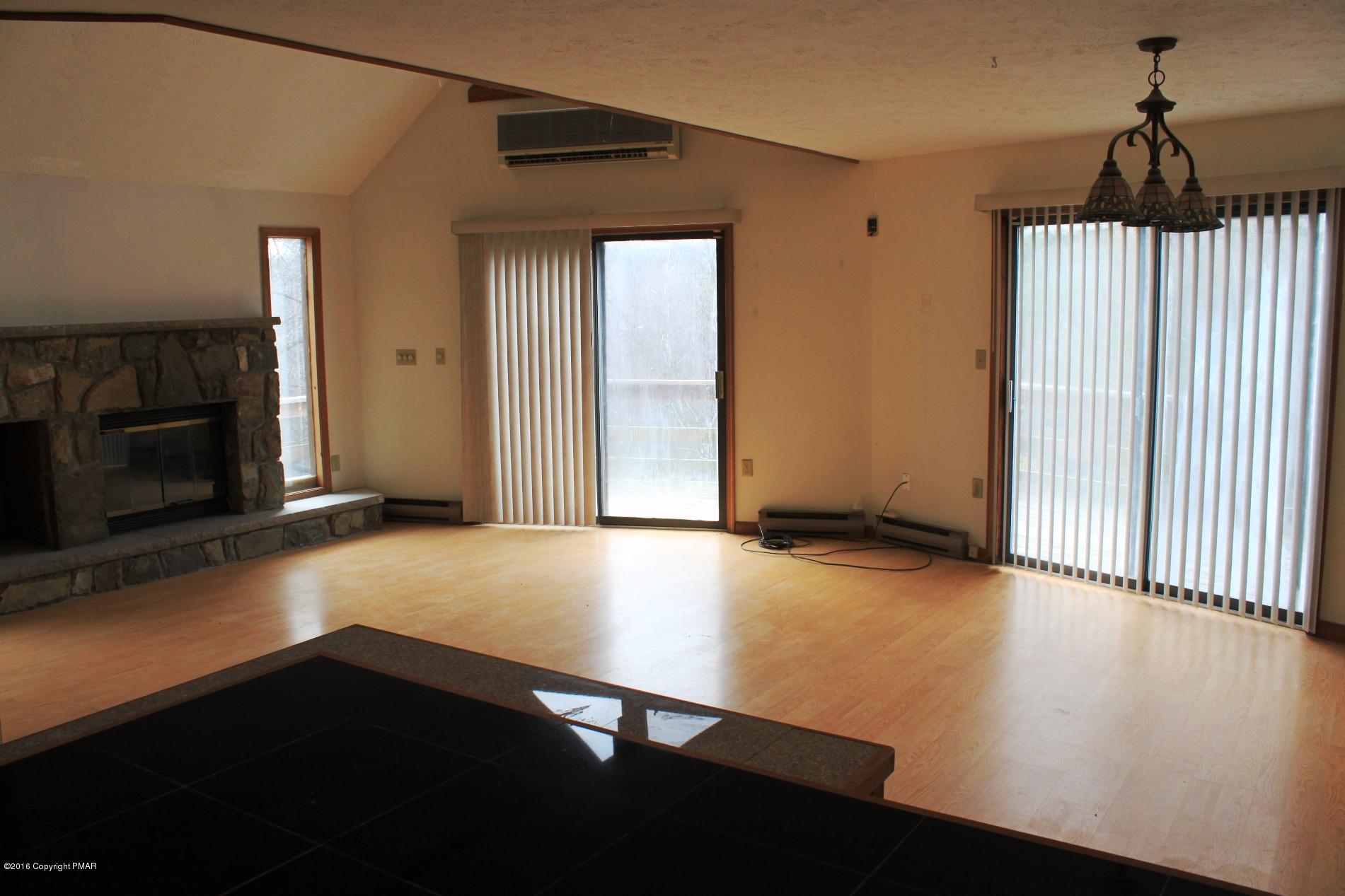 1421 Clover Road Long Pond, PA 18334 - Photo 6 of 26 a view of an empty room with a fireplace and a window