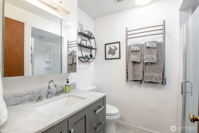 a bathroom with a granite countertop sink toilet and mirror
