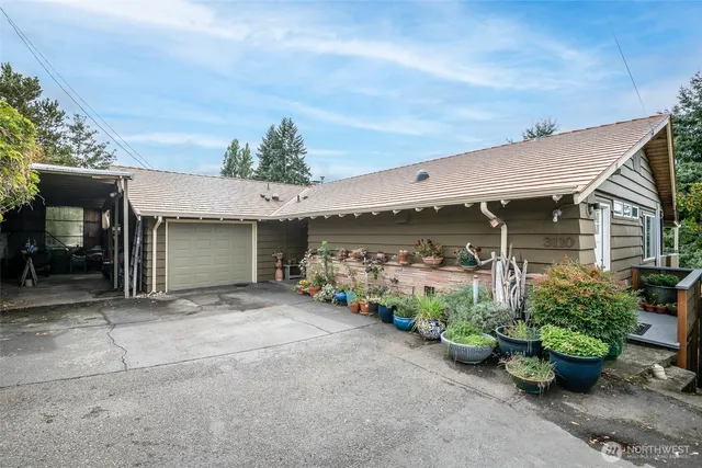 a view of a house with potted plants and a garage