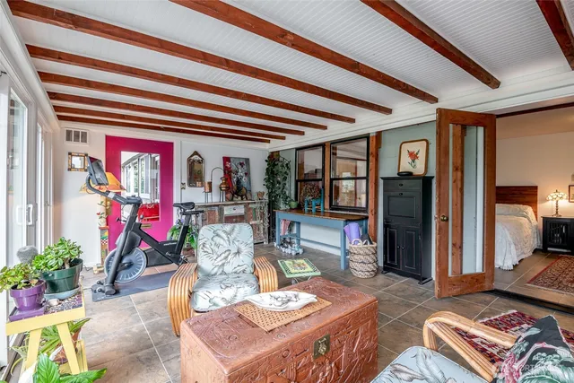 a living room with patio furniture and a potted plant