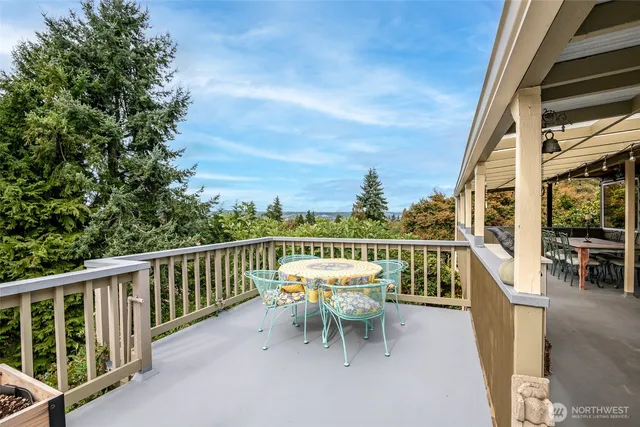 a balcony with wooden floor and outdoor seating