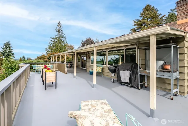 a view of a deck with dining table and chairs with wooden fence