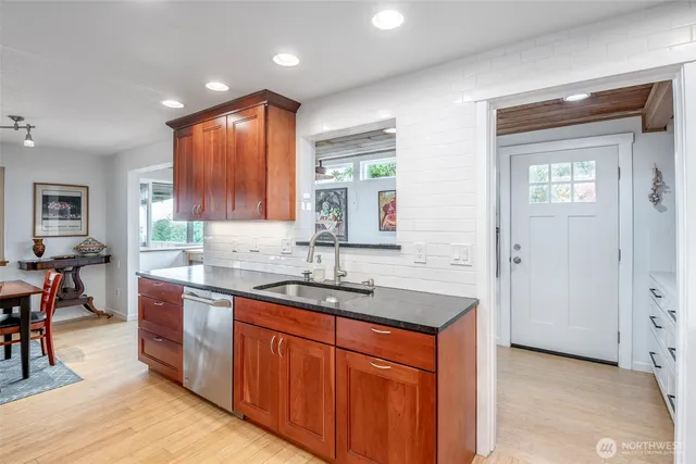 a kitchen with stainless steel appliances granite countertop wooden cabinets a sink and dishwasher