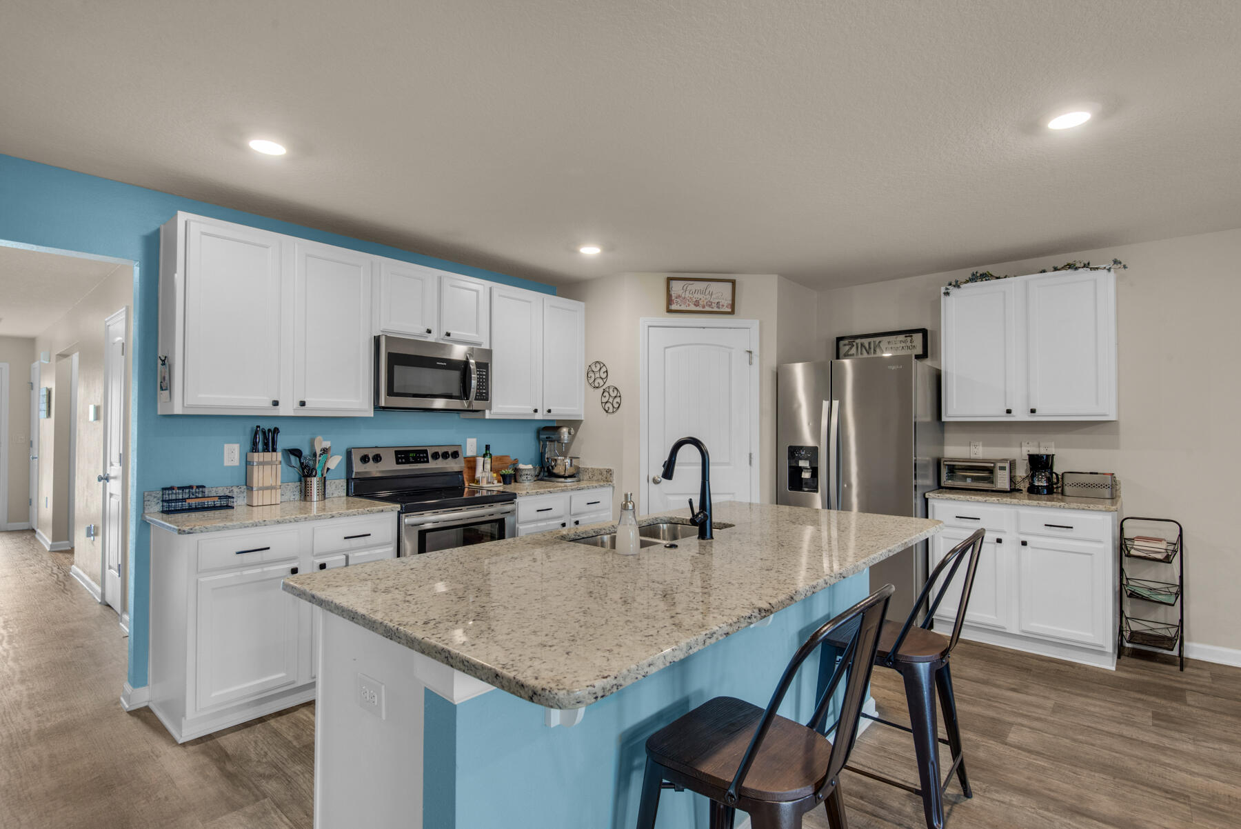 1016 Limpkin Street Crestview, FL 32539 - Photo 4 of 36 a kitchen with stainless steel appliances granite countertop a stove a sink a microwave a refrigerator white cabinets and wooden floor