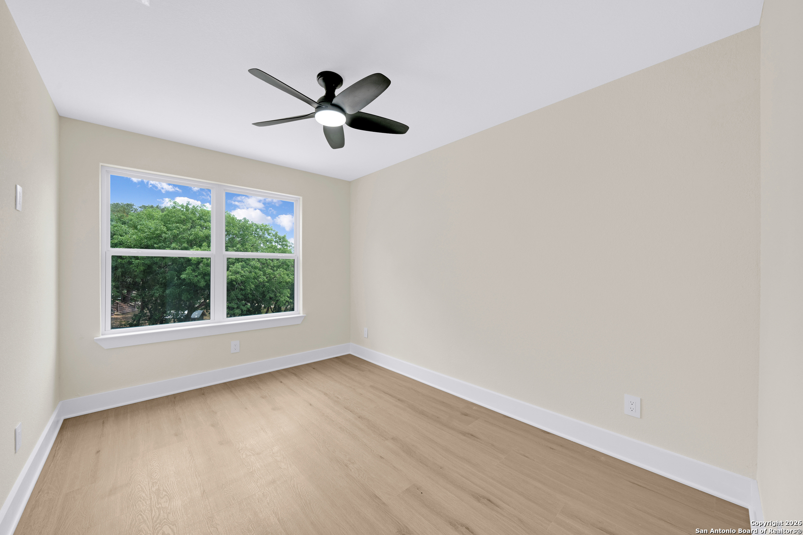 11710 Vance Jackson Road, Unit 702 San Antonio, TX 78230 - Photo 22 of 25 a view of a big room with wooden floor a ceiling fan and windows