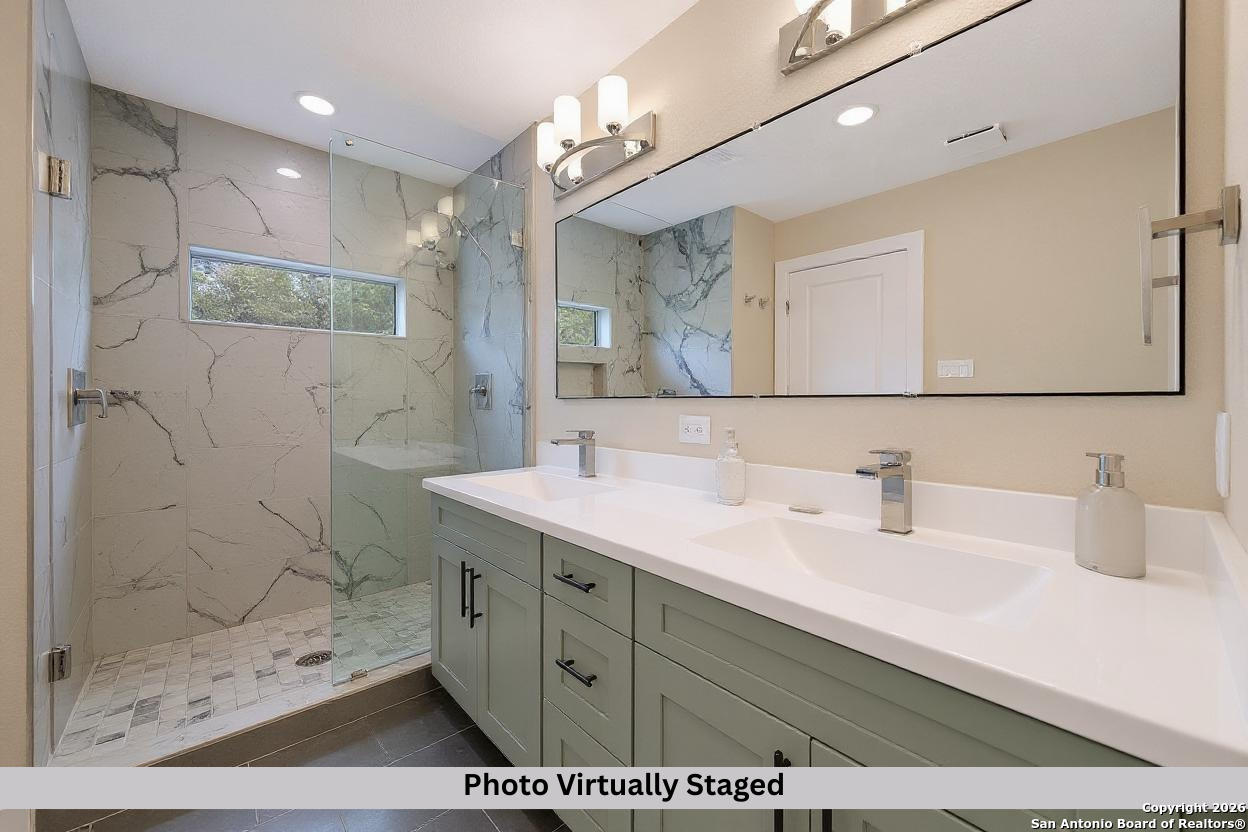 11710 Vance Jackson Road, Unit 702 San Antonio, TX 78230 - Photo 4 of 25 a bathroom with a sink a mirror a vanity and shower